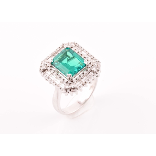 35 - An 18ct white gold, diamond, and emerald cocktail ring, set with a synthetic (hydrothermal) emerald-... 