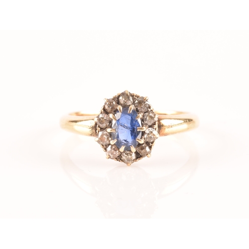 56 - An 18ct yellow gold, diamond, and sapphire cluster ring, set with a mixed oval-cut blue sapphire wit... 