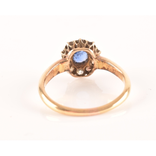 56 - An 18ct yellow gold, diamond, and sapphire cluster ring, set with a mixed oval-cut blue sapphire wit... 