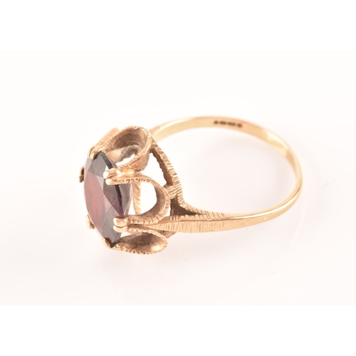 62 - A 9ct yellow gold and garnet ring, the raised basket setting centred with a six-claw set mixed oil c... 