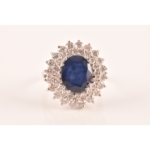 63 - A 14ct white gold, diamond, and sapphire cocktail ring, centred with a mixed oval-cut sapphire, meas... 