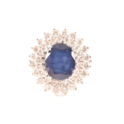 63 - A 14ct white gold, diamond, and sapphire cocktail ring, centred with a mixed oval-cut sapphire, meas... 