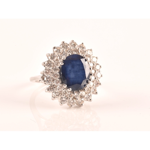 63 - A 14ct white gold, diamond, and sapphire cocktail ring, centred with a mixed oval-cut sapphire, meas... 