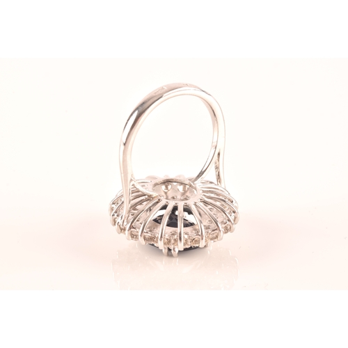 63 - A 14ct white gold, diamond, and sapphire cocktail ring, centred with a mixed oval-cut sapphire, meas... 