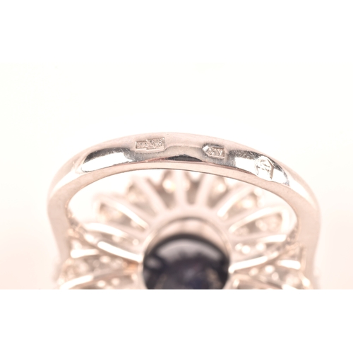 63 - A 14ct white gold, diamond, and sapphire cocktail ring, centred with a mixed oval-cut sapphire, meas... 