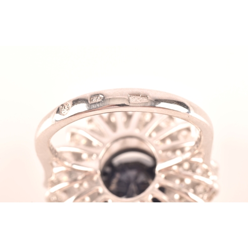 63 - A 14ct white gold, diamond, and sapphire cocktail ring, centred with a mixed oval-cut sapphire, meas... 