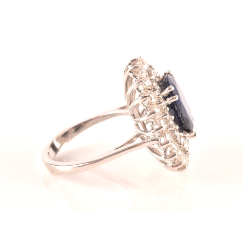 63 - A 14ct white gold, diamond, and sapphire cocktail ring, centred with a mixed oval-cut sapphire, meas... 