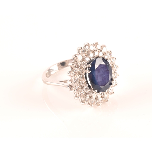 63 - A 14ct white gold, diamond, and sapphire cocktail ring, centred with a mixed oval-cut sapphire, meas... 