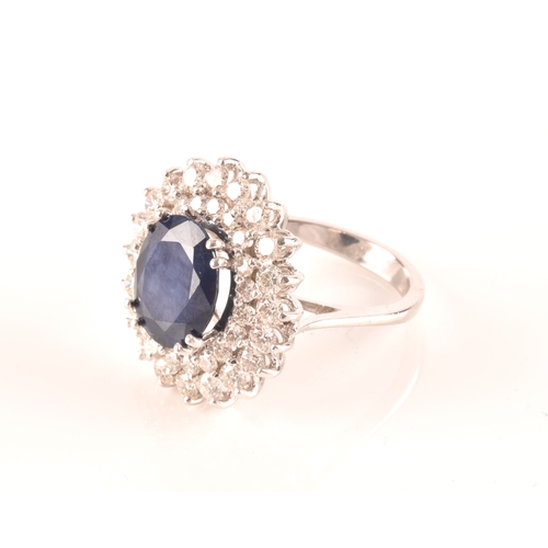 63 - A 14ct white gold, diamond, and sapphire cocktail ring, centred with a mixed oval-cut sapphire, meas... 