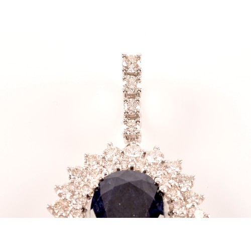 65 - A diamond and sapphire cluster pendant, set with a mixed oval-cut sapphire, measuring approximately ... 