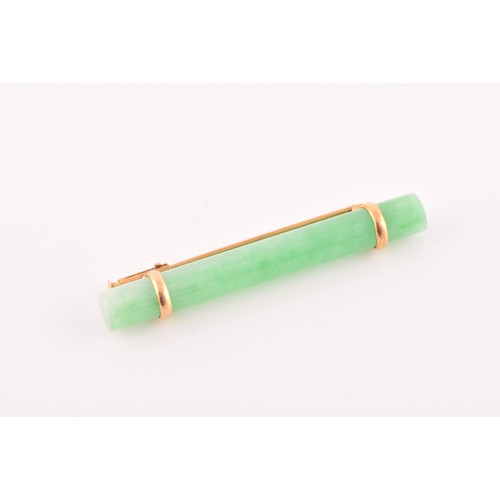 66 - A yellow metal mounted jade bar brooch, set with a polished green jade baton 5.8 cm long, mount unma... 