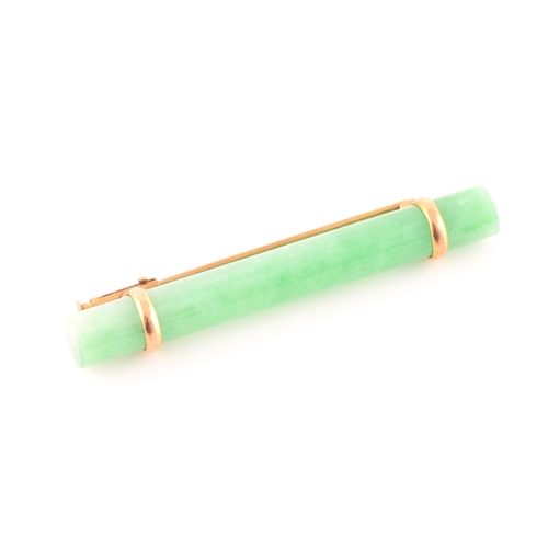 66 - A yellow metal mounted jade bar brooch, set with a polished green jade baton 5.8 cm long, mount unma... 