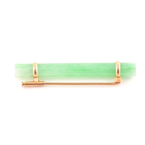 66 - A yellow metal mounted jade bar brooch, set with a polished green jade baton 5.8 cm long, mount unma... 