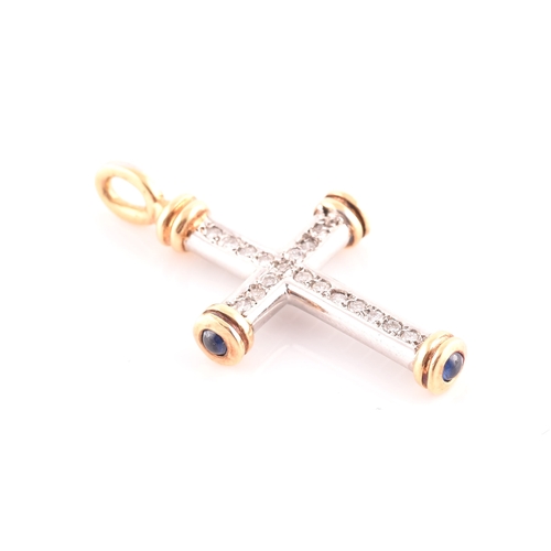 67 - An 18ct gold, diamond, and sapphire cross, the white gold cross mount inset with round brilliant-cut... 