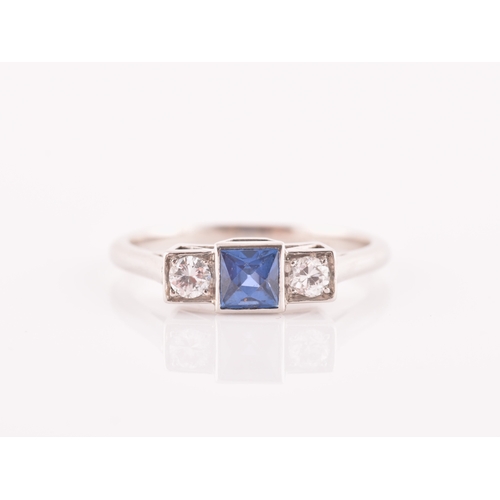 68 - A diamond and sapphire ring, set with a fancy square-cut sapphire, flanked with two round brilliant-... 