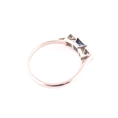 68 - A diamond and sapphire ring, set with a fancy square-cut sapphire, flanked with two round brilliant-... 