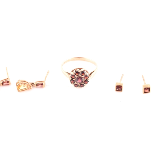 70 - A 9ct yellow gold and garnet floral cluster ring, pave set with mixed round-cut red garnets, size N,... 