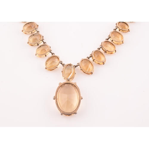 77 - A citrine riviere necklace, claw-set in silver gilt mount, the large mixed oval-cut drop measuring a... 