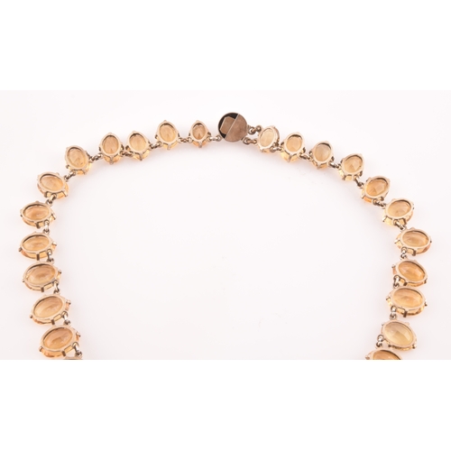 77 - A citrine riviere necklace, claw-set in silver gilt mount, the large mixed oval-cut drop measuring a... 