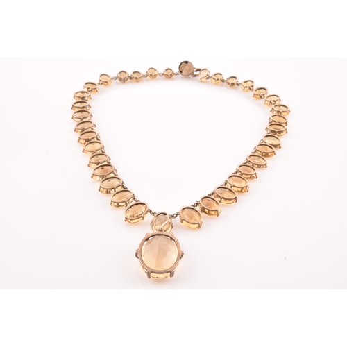 77 - A citrine riviere necklace, claw-set in silver gilt mount, the large mixed oval-cut drop measuring a... 