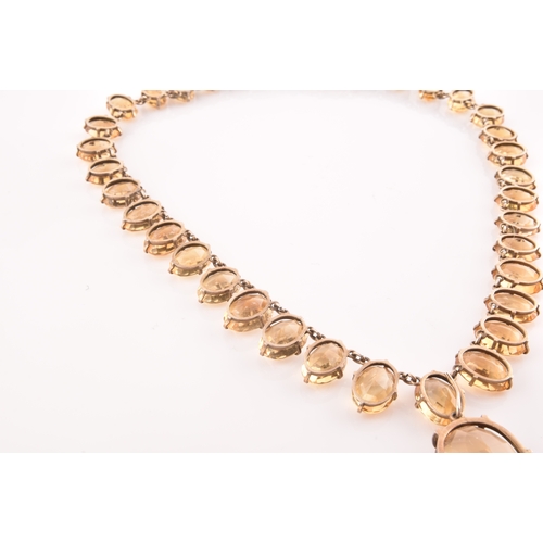 77 - A citrine riviere necklace, claw-set in silver gilt mount, the large mixed oval-cut drop measuring a... 