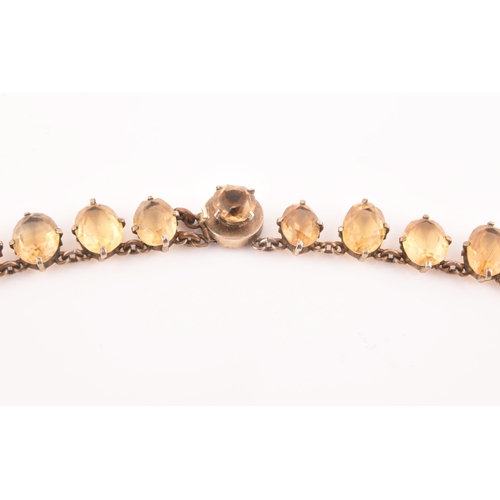 77 - A citrine riviere necklace, claw-set in silver gilt mount, the large mixed oval-cut drop measuring a... 