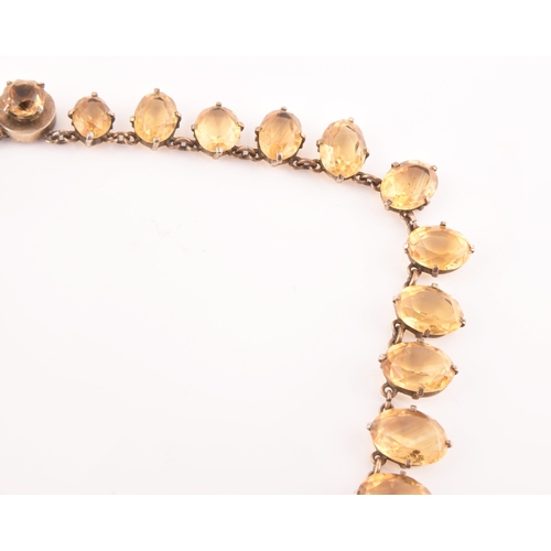 77 - A citrine riviere necklace, claw-set in silver gilt mount, the large mixed oval-cut drop measuring a... 