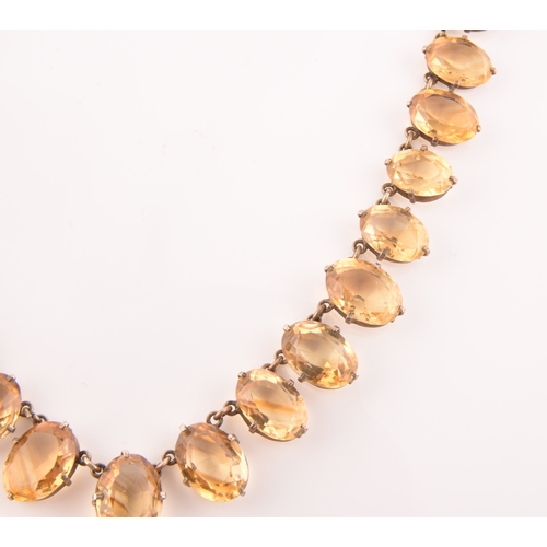 77 - A citrine riviere necklace, claw-set in silver gilt mount, the large mixed oval-cut drop measuring a... 