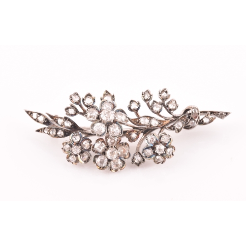 78 - A Victorian diamond floral spray brooch, the flowers and leaves inset with old-cut diamonds, the lar... 