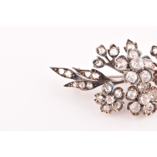 78 - A Victorian diamond floral spray brooch, the flowers and leaves inset with old-cut diamonds, the lar... 