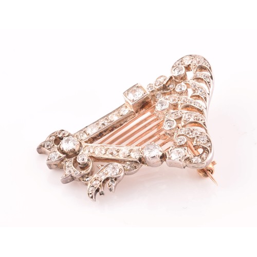 84 - A late 19th / early 20th diamond harp brooch, the scrolled decorative mount inset with mixed old-cut... 