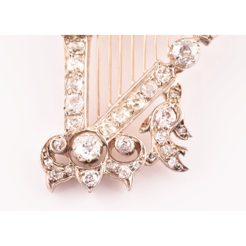 84 - A late 19th / early 20th diamond harp brooch, the scrolled decorative mount inset with mixed old-cut... 