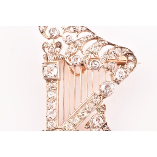 84 - A late 19th / early 20th diamond harp brooch, the scrolled decorative mount inset with mixed old-cut... 