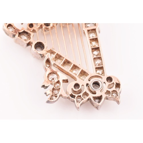 84 - A late 19th / early 20th diamond harp brooch, the scrolled decorative mount inset with mixed old-cut... 