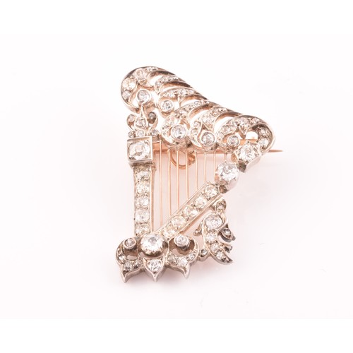 84 - A late 19th / early 20th diamond harp brooch, the scrolled decorative mount inset with mixed old-cut... 