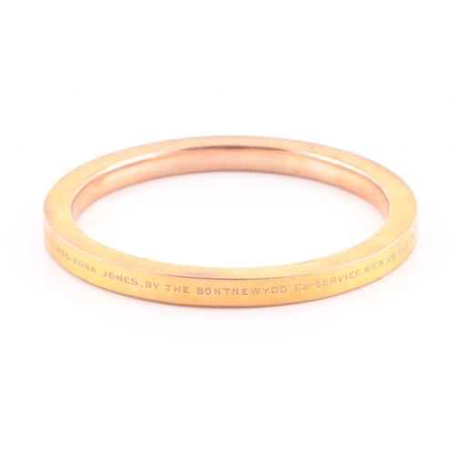 85 - An early 20th century 9ct yellow gold hollow bangle, the bracelet bearing personalised inscription: ... 