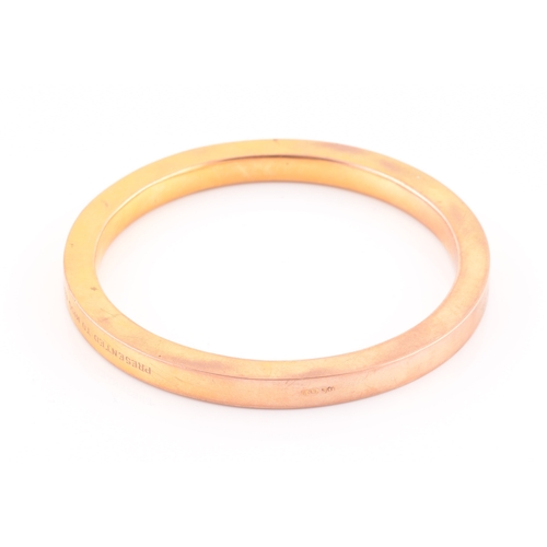 85 - An early 20th century 9ct yellow gold hollow bangle, the bracelet bearing personalised inscription: ... 