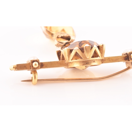 87 - A late 19th / early 20th century yellow metal, citrine, and pearl bar brooch, the triple bar mount i... 