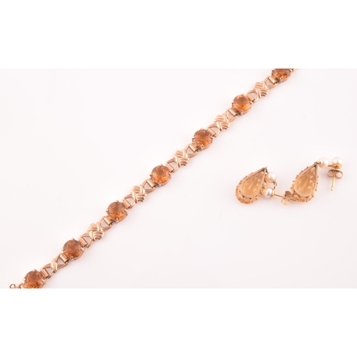 90 - A 9ct yellow gold and orange citrine bracelet, fancy links interspersed with eight round-cut claw-se... 