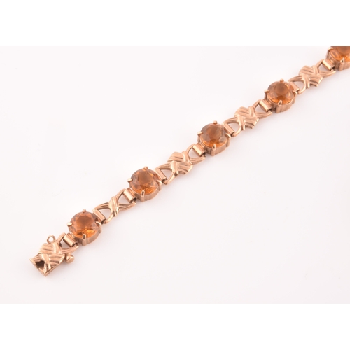 90 - A 9ct yellow gold and orange citrine bracelet, fancy links interspersed with eight round-cut claw-se... 