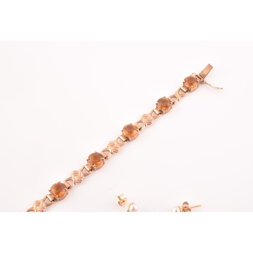 90 - A 9ct yellow gold and orange citrine bracelet, fancy links interspersed with eight round-cut claw-se... 