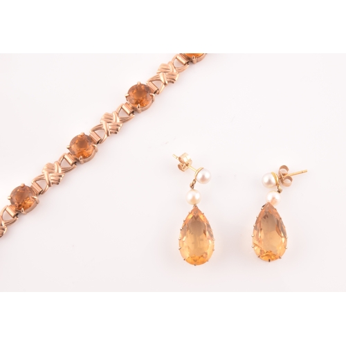 90 - A 9ct yellow gold and orange citrine bracelet, fancy links interspersed with eight round-cut claw-se... 