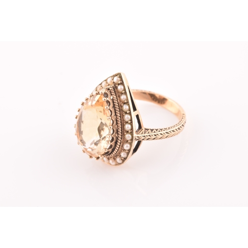 94 - A 9ct yellow gold, citrine, and seed pearl ring, the pear-shaped central citrine measuring approxima... 