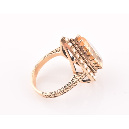 94 - A 9ct yellow gold, citrine, and seed pearl ring, the pear-shaped central citrine measuring approxima... 