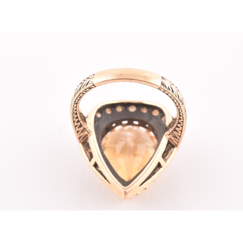 94 - A 9ct yellow gold, citrine, and seed pearl ring, the pear-shaped central citrine measuring approxima... 