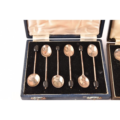 180 - A collection of silver items including a set of four shell shaped salts, silver cased coffee bean en... 