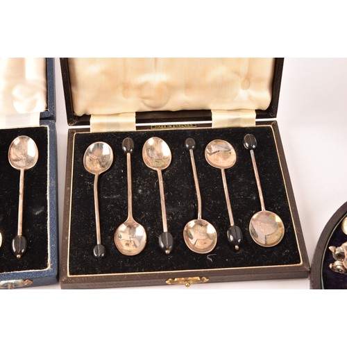 180 - A collection of silver items including a set of four shell shaped salts, silver cased coffee bean en... 