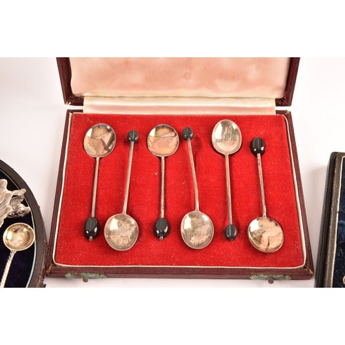 180 - A collection of silver items including a set of four shell shaped salts, silver cased coffee bean en... 