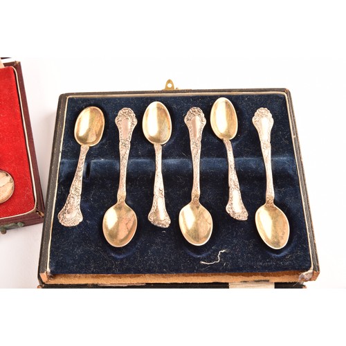 180 - A collection of silver items including a set of four shell shaped salts, silver cased coffee bean en... 