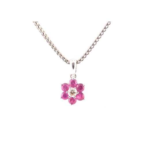 101 - An 18ct white gold, diamond, and ruby floral cluster pendant, centred with a round brilliant-cut dia... 